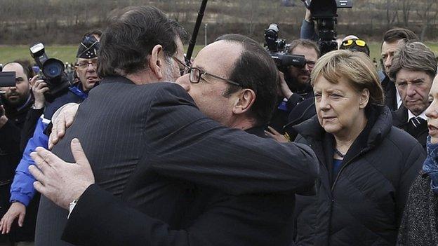 President Francois Hollande (centre) embraces Spains Prime Minister Mariano Rajoy as German Chancellor Angela Merkel looks on. 25 March 2015