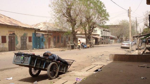 A man asleep on a cart in Sabon Gari, Kano, Nigeria