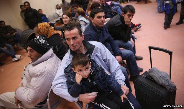 Migrants wait to register at the Central Registration Office for Asylum Seekers in Berlin on 11 March 2015