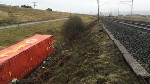 Freight container on its side next to the track