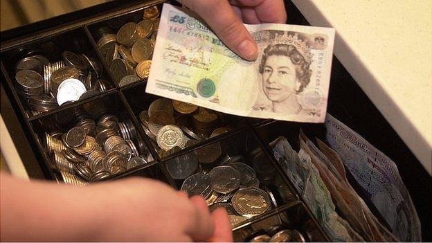 Shop assistant sorting change in a till