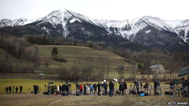 Reporters and television crews gather near where French police and military helicopters are landing on March 25, 2015 in Seyne-les-Alpes, France