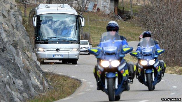 A bus transporting the families of the Germanwings Airbus A320 victims, escorted by French motorcycle policemen, arrive in Seyne-les-Alpes on March 26, 2015