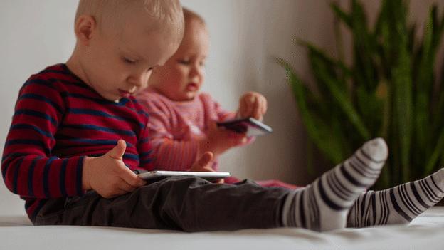 Babies with tablet and phone