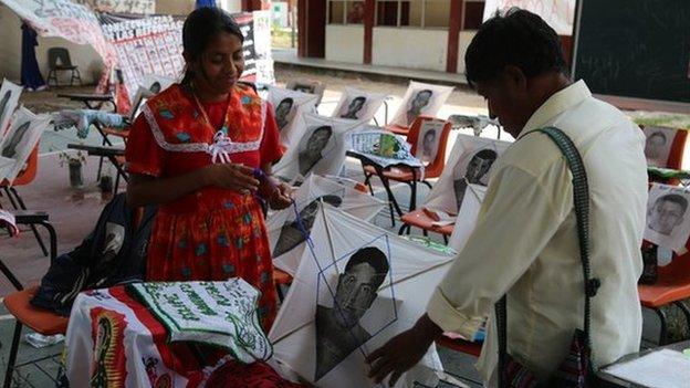 Woman and man looks at photos of missing students