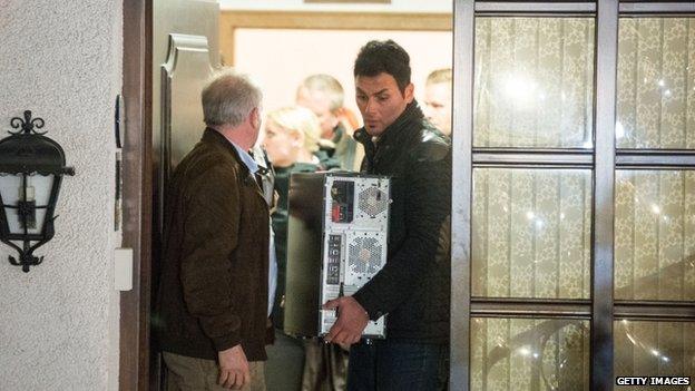 A police officers carries a computer from the house Andreas Lubitz shared with his parents in Montabaur. Photo: 26 March 2015