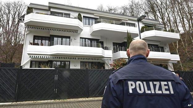 A police officer stands in front of an apartment building where they believe Andreas Lubitz, the co-pilot of the crashed Germanwings airliner jet, lived on 26 March, 2015,