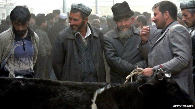 Uighur men gather at a bazaar to sell their live sheep in the Xinjiang region (7 November 2013)