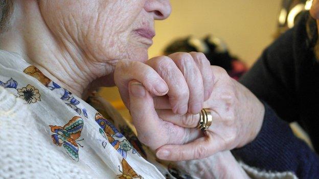 Carer holding elderly person's hand