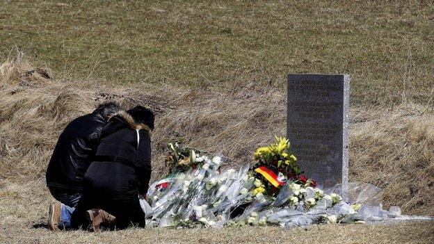 Relatives lay flowers in front of the monument in homage to the victims of Germanwings Flight 4U 9525 in Le Vernet, southeastern France, 27 March 2015.