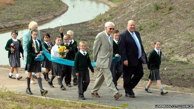 Joe Anderson and children walk through Alt meadows