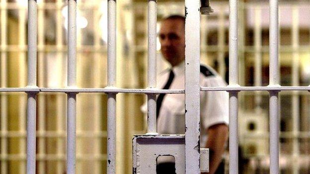 Prison officer seen through bars