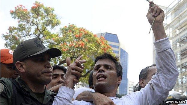 Leopoldo Lopez is escorted by the national guard after he turned himself in on 18 February, 2014.