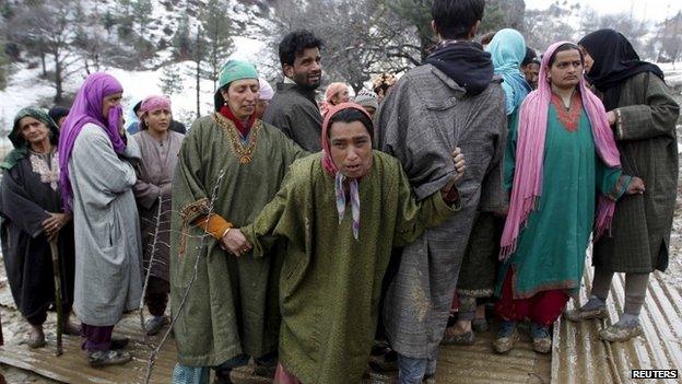 Unidentified relatives of victims react at the site of a damaged house after a hillside collapsed onto a house at Laden village, west of Srinagar, March 30, 2015.