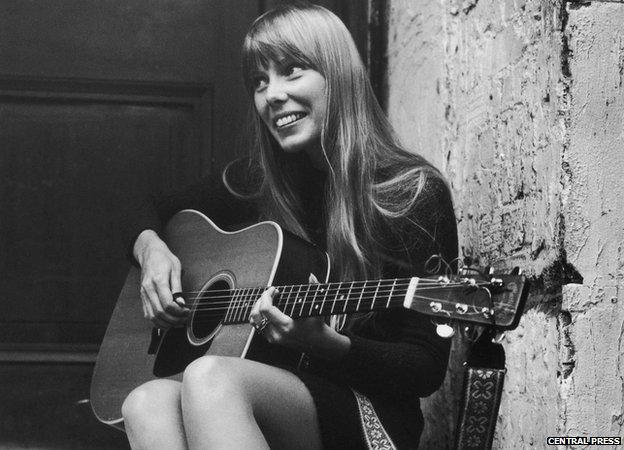 Canadian folk singer and songwriter Joni Mitchell, strumming her guitar outside The Revolution club in London 18 September 1968