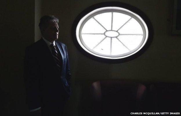DUP Leader Peter Robinson stands by a window as he waits to begin a press conference in Antrim, Northern Ireland