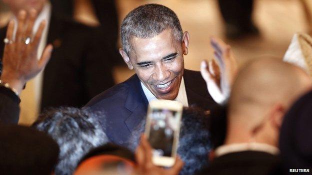 Barack Obama illuminated by the light of a mobile phone