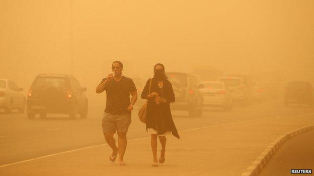 A woman walks with her face covered during a sand storm in Dubai 02 April 2015.