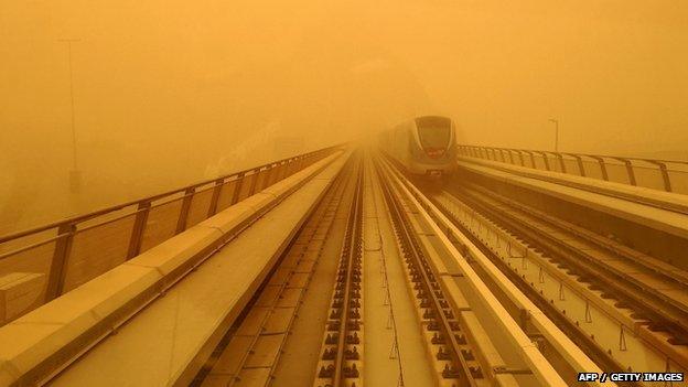 A Dubai metro train is seen driving amid a sandstorm that engulfed the city on 02 April 2015