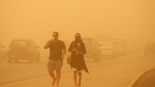 A woman walks with her face covered during a sand storm in Dubai 02 April 2015.