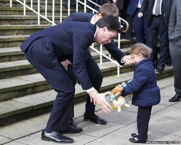 Labour Party leader Ed Miliband greets a child as he arrives at an election campaign event at the town hall in Bury,