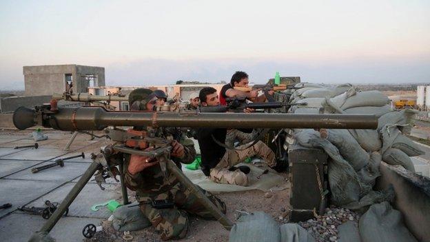 Iraqi security forces and allied Shiite militiamen clash with IS fighters at the front line in the Qadisiyah neighborhood in Tikrit
