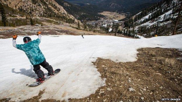 A snowboarder threads his way through patches of dirt at Squaw Valley Ski Resort, March 21, 2015 in Olympic Valley, California.