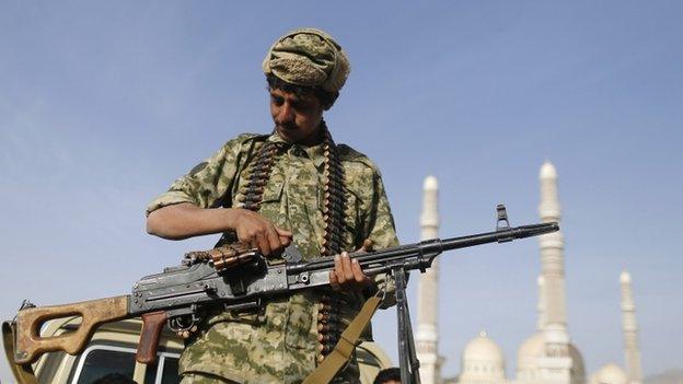 A Houthi fighter holds a machine gun as he rides a truck near the Presidential Palace in Sanaa