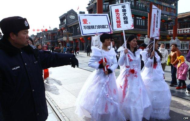 Li Tingting in the middle and two others wear paint-spattered wedding dresses