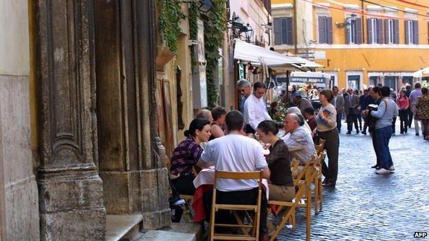 Diners eating outside a restaurant in Italy