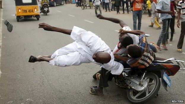 Supporters of the presidential candidate Muhammadu Buhari and his All Progressive Congress with a motorbike during celebrations in Kano