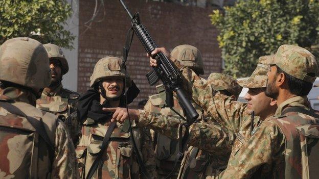 Pakistan army soldiers surround a Shia mosque attacked by suicide bombers and gunmen in Peshawar, Pakistan, Friday, Feb. 13, 2015.