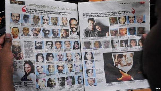 A man reads a newspaper with portraits of Westgate mall victims on 19 September 2014 as Kenya commemorates the first anniversary since the terror attack that happened in the Nairobi's shopping centre