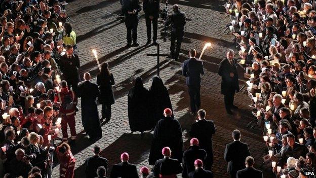 Nuns hold the cross during a station of the Via Crucis (Way of the Cross) torchlight procession celebrated by Pope Francis in front of the Colosseum on Good Friday, in Rome