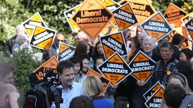 Liberal Democrat Party leader Nick Clegg, facing camera centre left, speaks to the media while being surrounded by supporter outside the Grove Pub, while on the General Election campaign trail in Surbiton