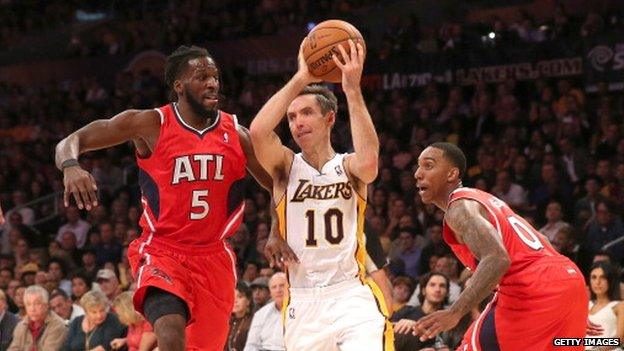 Steve Nash #10 of the Los Angeles Lakers drives between DeMarre Carroll #5 and Jeff Teague #0 of the Atlanta Hawks at Staples Center on 3 November 2013 in Los Angeles, California