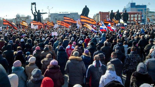 Several thousand people carry patriotic flags as they demonstrate against the proposed production of Wagner's Tannhauser, outside the state theatre in Novosibirsk (29 March 2015)