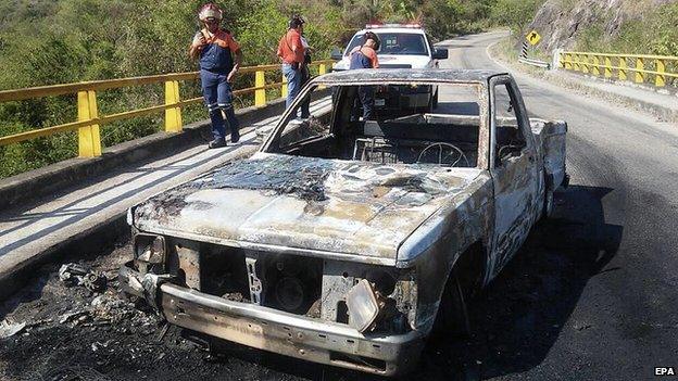 A burnt-out vehicle after a shooting between Mexican authorities and alleged criminals in Soyatan, Mexico, on 6 April 2015