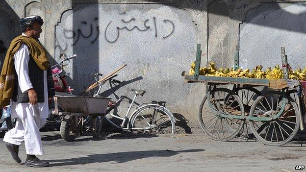 A Pakistani pedestrian walks past a wall graffiti which reads Daesh, the arabic acronym for Islamic State (IS), in Quetta on 24 November 2014.