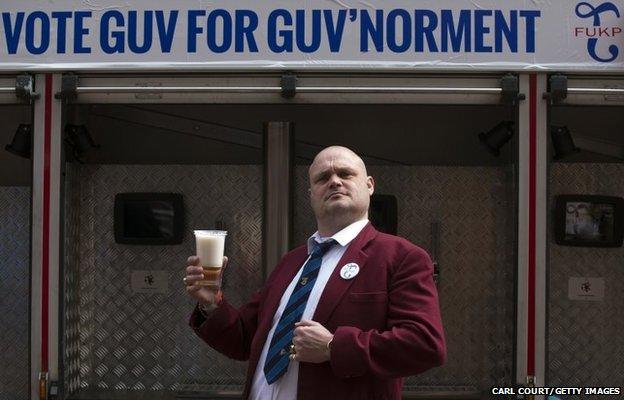 Alastair James Hay, better known as comedian "Al Murray" who portrays an English pub landlord, poses with a pint of beer poured from a fire engine converted into a mobile pub after handing in his nomination papers at Thanet council offices