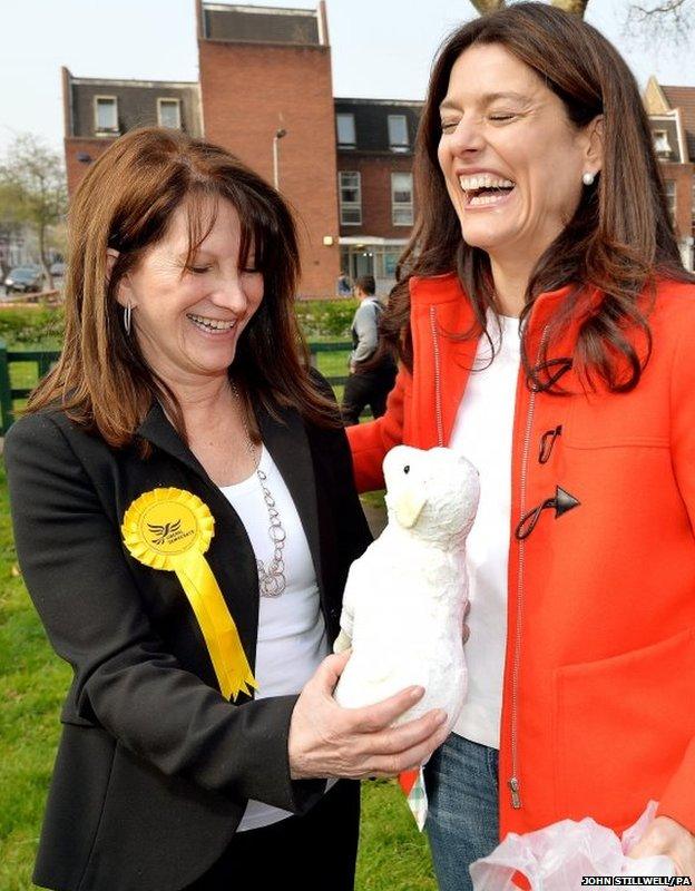 Miriam Clegg (right) the wife of Liberal Democrats leader Nick Clegg, gives a present of a cuddly toy lamb to Lynne Featherstone