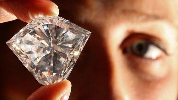 Man inspecting a large diamond