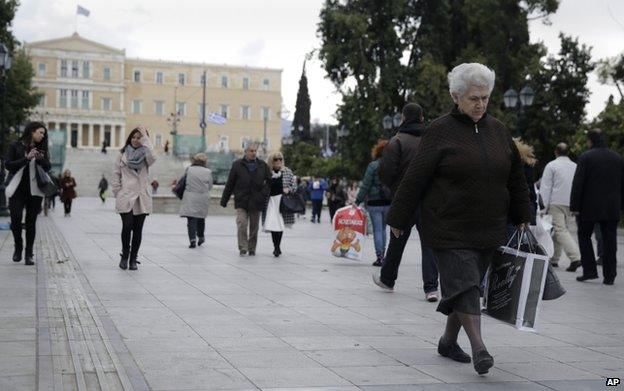 A woman walks at Syntagma square in front of the Greek parliament in central Athens, Wednesday, 8 April 2015