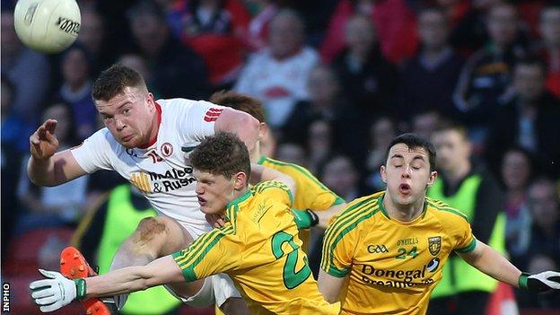 Tyrone's Ruairi McGlone is tackled by Michael Miller and Conor Morrison