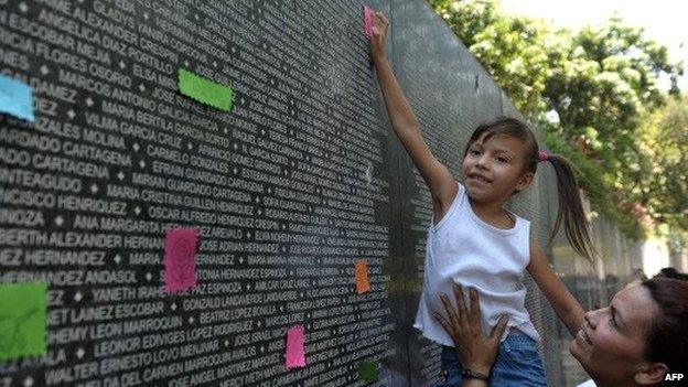 A girl places a note at the War Victims Memorial, during a ceremony to conmemorate the day of the disappeared children in San Salvador, El Salvador on March 29, 2012