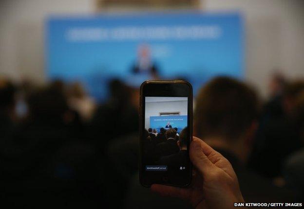 A reporter live streams via a twitter as Defence Secretary Michael Fallon gives a press conference