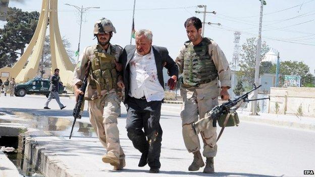 Members of the Afghan police forces help a man wounded when gunmen stormed the office of the Attorney General in Mazar-e-Sharif, Afghanistan, 09 April 2015.