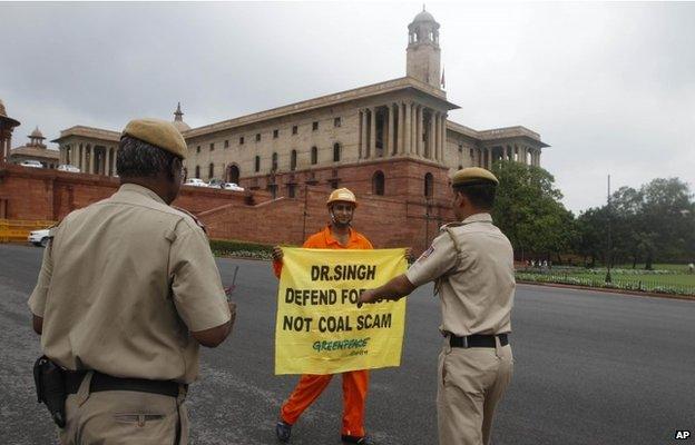 Indian policemen prepare to remove a Greenpeace activist as he holds a banner near the area of government offices and the Indian Parliament in New Delhi in 2012