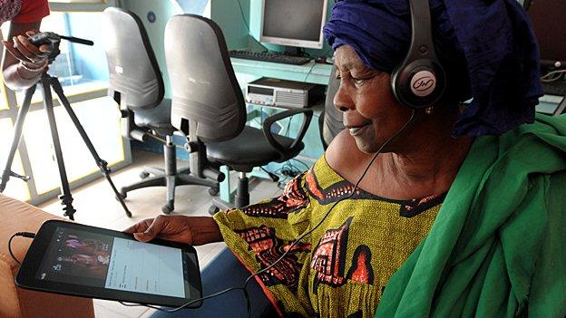 A woman uses a tablet at an internet cafe in Dakar, Senegal