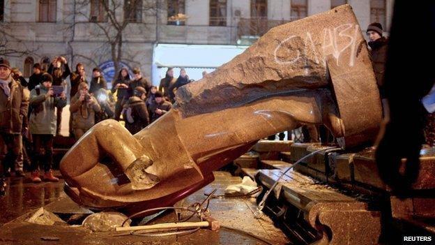 People surround a statue of Soviet state founder Vladimir Lenin, which was toppled by protesters during a rally organized by supporters of EU integration in Kiev, 8 December, 2013. Crowds toppled a statue of Soviet state founder Vladimir Lenin in the Ukrainian capital and attacked it with hammers on Sunday in the latest mass protests against President Viktor Yanukovich and his plans for closer ties with Russia.